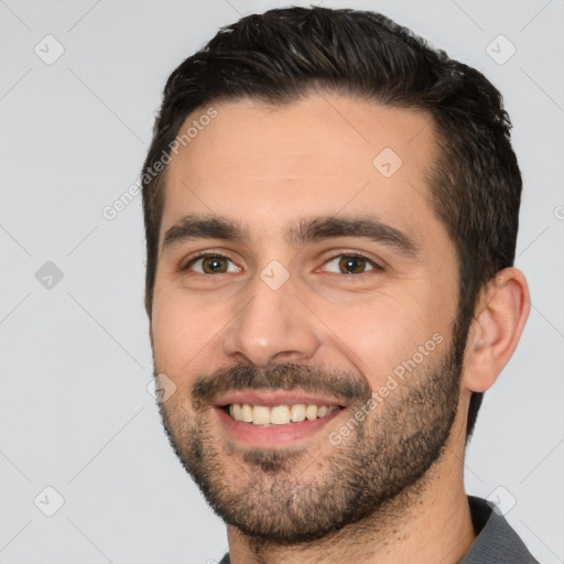 Joyful white young-adult male with short  black hair and brown eyes