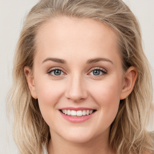 Joyful white young-adult female with long  brown hair and blue eyes