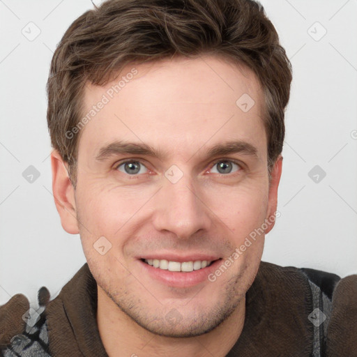 Joyful white young-adult male with short  brown hair and grey eyes