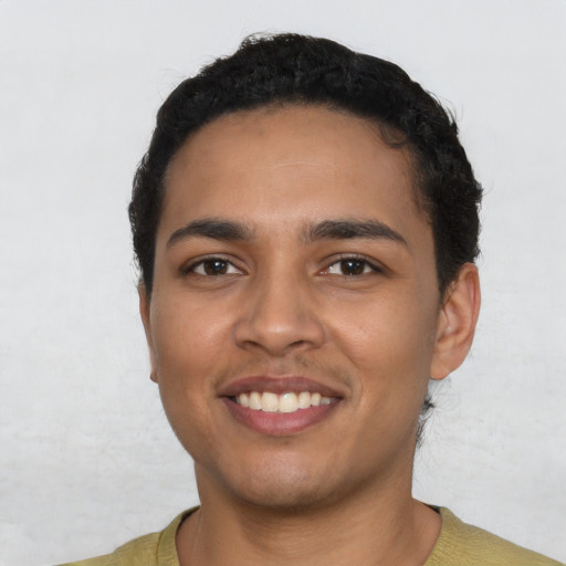 Joyful latino young-adult male with short  black hair and brown eyes