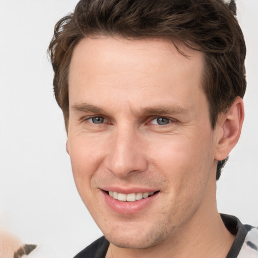 Joyful white adult male with short  brown hair and grey eyes