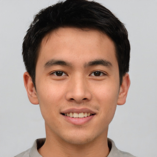 Joyful asian young-adult male with short  black hair and brown eyes