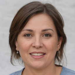 Joyful white adult female with medium  brown hair and grey eyes