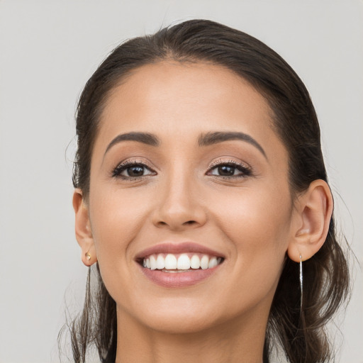 Joyful white young-adult female with long  brown hair and brown eyes