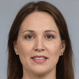 Joyful white adult female with long  brown hair and grey eyes