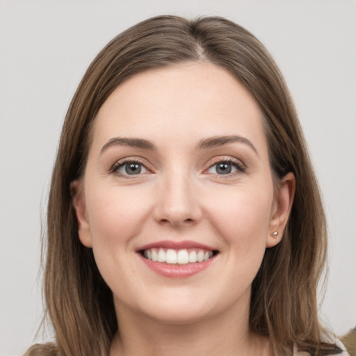 Joyful white young-adult female with long  brown hair and grey eyes