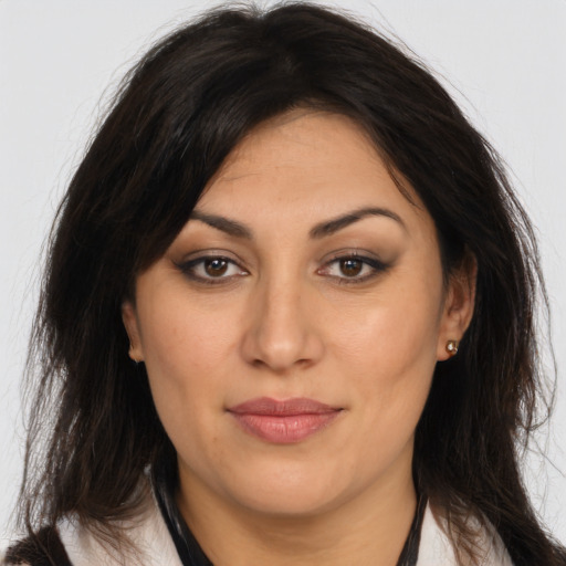 Joyful latino adult female with long  brown hair and brown eyes