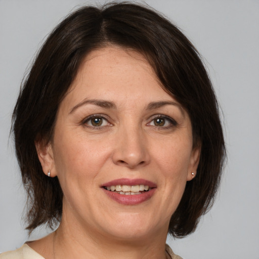 Joyful white adult female with medium  brown hair and brown eyes