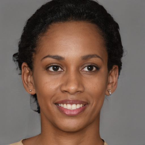 Joyful black young-adult female with short  brown hair and brown eyes