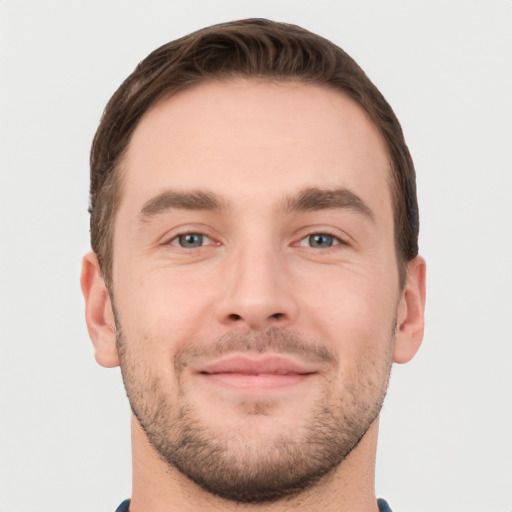 Joyful white young-adult male with short  brown hair and grey eyes