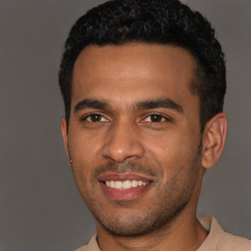 Joyful black young-adult male with short  brown hair and brown eyes