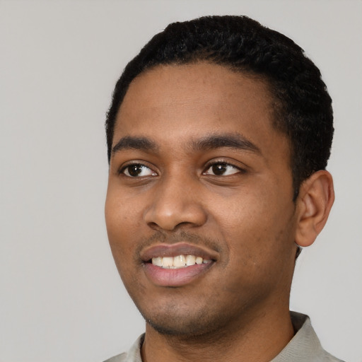 Joyful black young-adult male with short  black hair and brown eyes