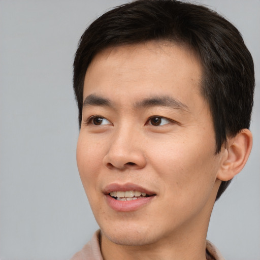 Joyful asian young-adult male with short  brown hair and brown eyes