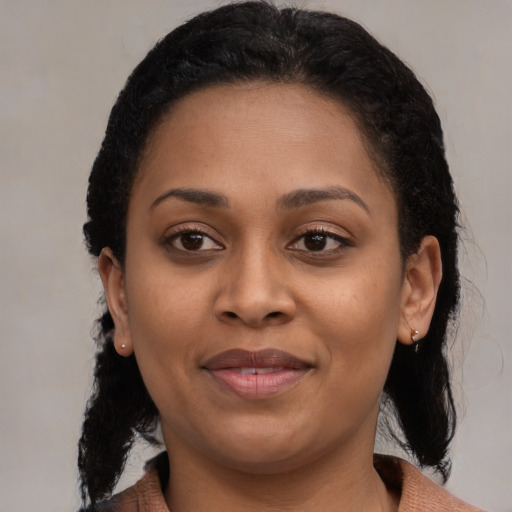 Joyful black young-adult female with medium  brown hair and brown eyes