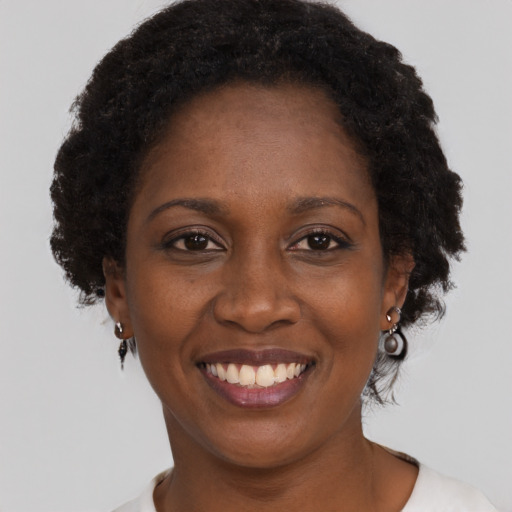Joyful black adult female with short  brown hair and brown eyes