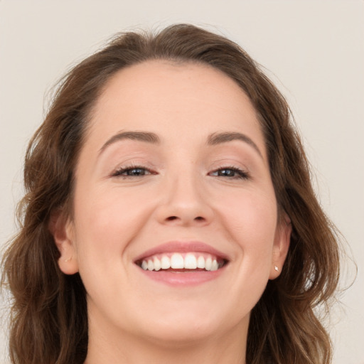 Joyful white young-adult female with long  brown hair and blue eyes