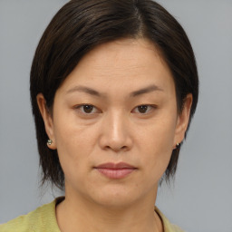 Joyful asian young-adult female with medium  brown hair and brown eyes