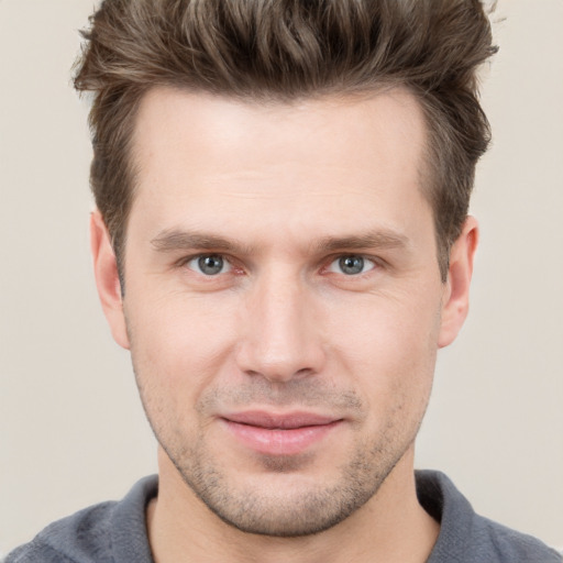 Joyful white young-adult male with short  brown hair and grey eyes