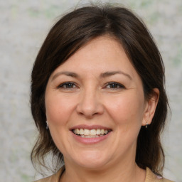 Joyful white adult female with medium  brown hair and brown eyes