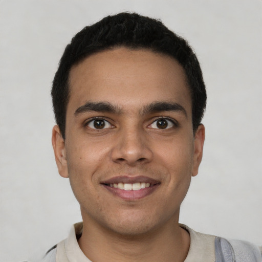 Joyful latino young-adult male with short  black hair and brown eyes