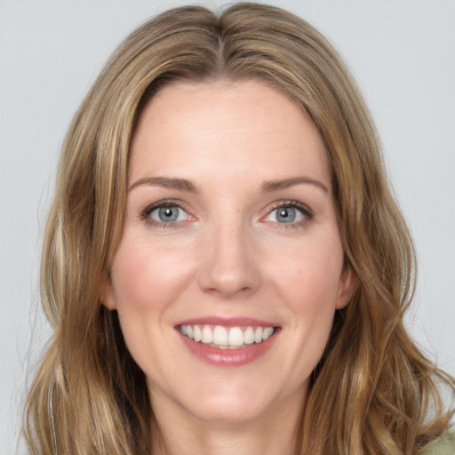 Joyful white young-adult female with long  brown hair and green eyes