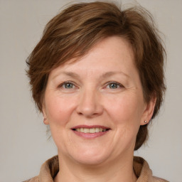 Joyful white adult female with medium  brown hair and grey eyes