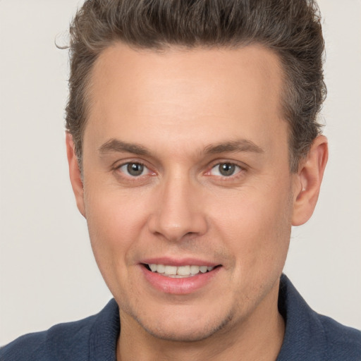 Joyful white adult male with short  brown hair and brown eyes