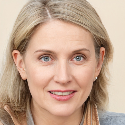 Joyful white adult female with medium  brown hair and blue eyes