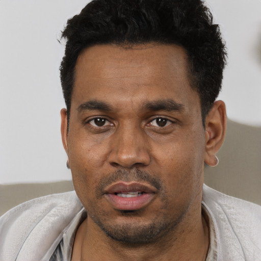 Joyful black young-adult male with short  black hair and brown eyes