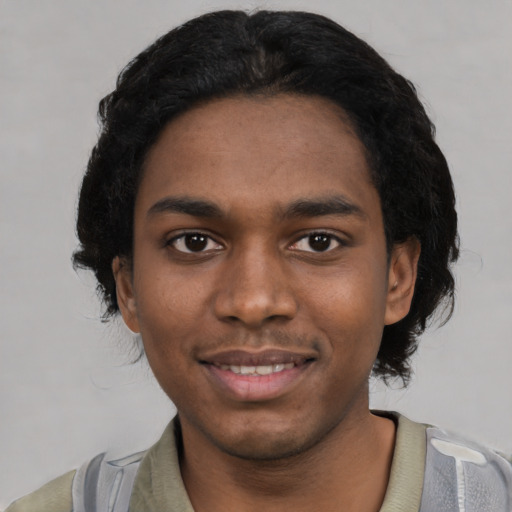 Joyful black young-adult male with short  black hair and brown eyes