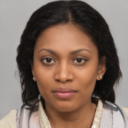 Joyful black young-adult female with long  black hair and brown eyes
