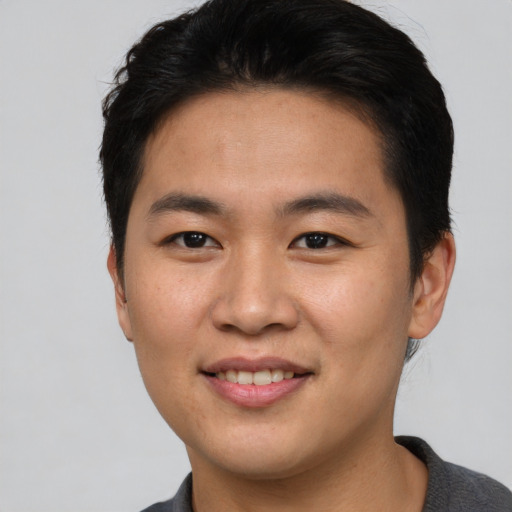 Joyful asian young-adult male with short  brown hair and brown eyes