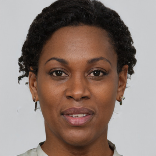 Joyful black young-adult female with short  brown hair and brown eyes