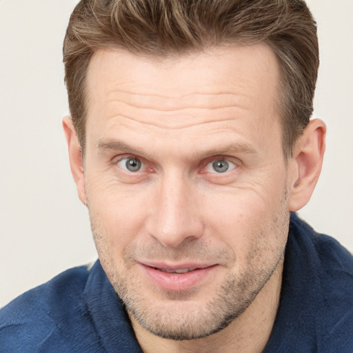 Joyful white adult male with short  brown hair and grey eyes