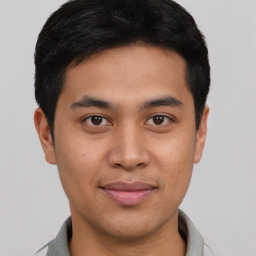 Joyful latino young-adult male with short  brown hair and brown eyes