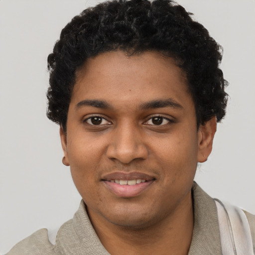 Joyful black young-adult male with short  black hair and brown eyes