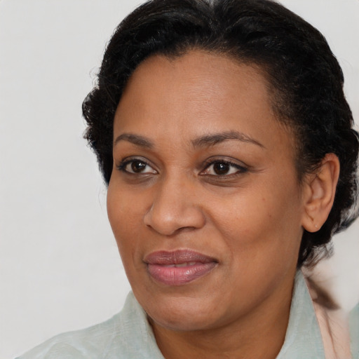 Joyful black adult female with medium  brown hair and brown eyes