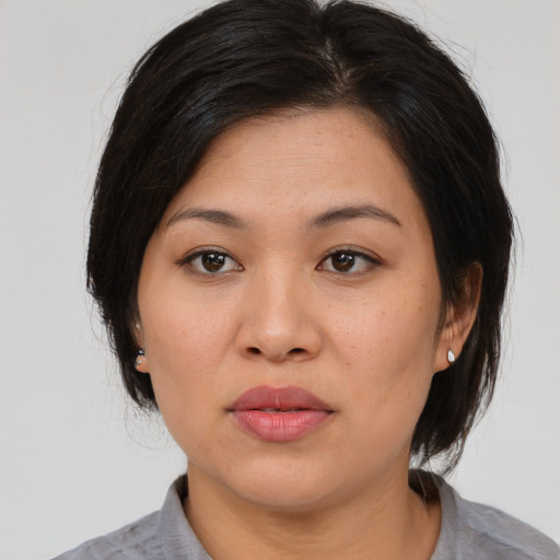 Joyful asian young-adult female with medium  black hair and brown eyes