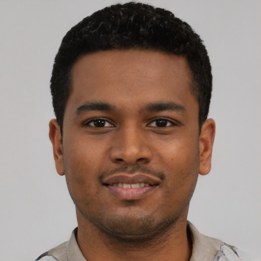 Joyful black young-adult male with short  black hair and brown eyes