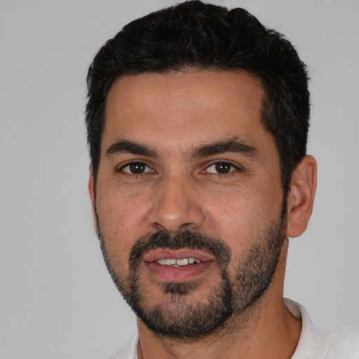 Joyful white young-adult male with short  black hair and brown eyes