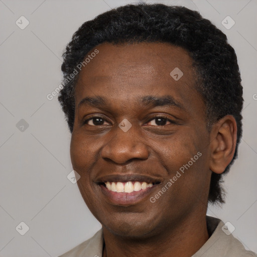 Joyful black young-adult male with short  black hair and brown eyes