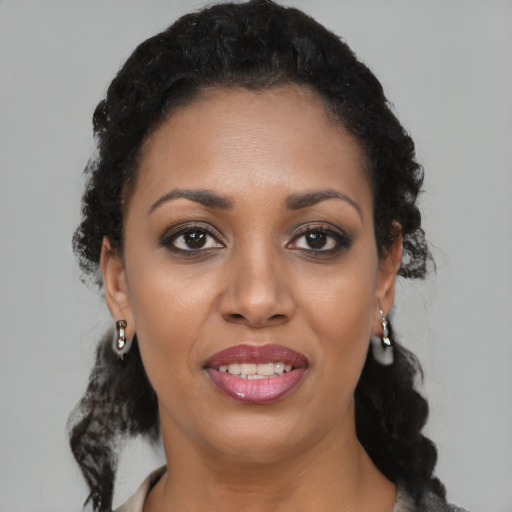 Joyful black young-adult female with medium  black hair and brown eyes