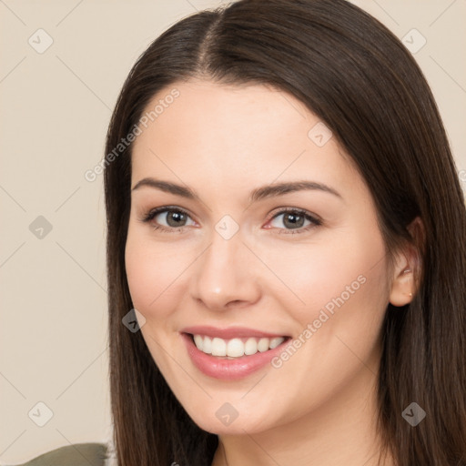 Joyful white young-adult female with long  brown hair and brown eyes