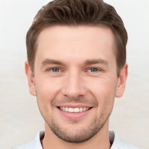 Joyful white young-adult male with short  brown hair and grey eyes