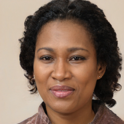 Joyful black adult female with medium  brown hair and brown eyes