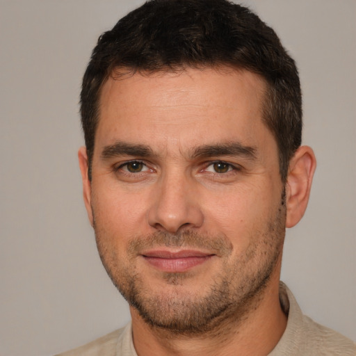 Joyful white young-adult male with short  brown hair and brown eyes