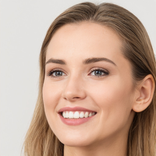 Joyful white young-adult female with long  brown hair and grey eyes