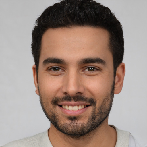 Joyful white young-adult male with short  black hair and brown eyes