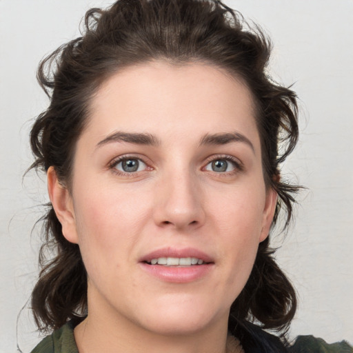 Joyful white young-adult female with medium  brown hair and grey eyes