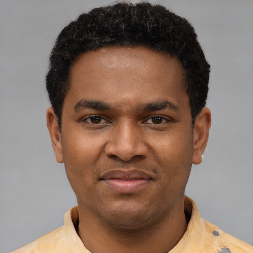 Joyful black young-adult male with short  brown hair and brown eyes